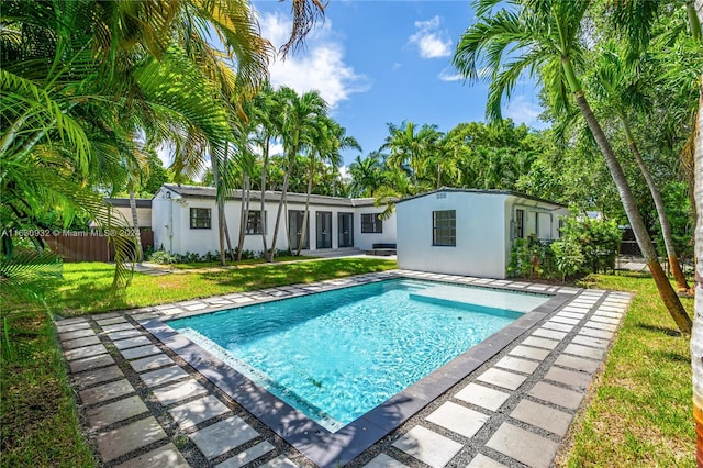 view of pool featuring a patio and a yard