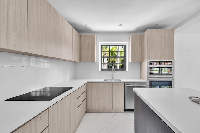 kitchen with sink, light brown cabinets, appliances with stainless steel finishes, and light tile patterned floors