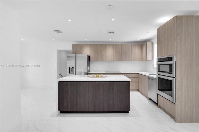 kitchen featuring light tile patterned floors, a center island with sink, and stainless steel appliances