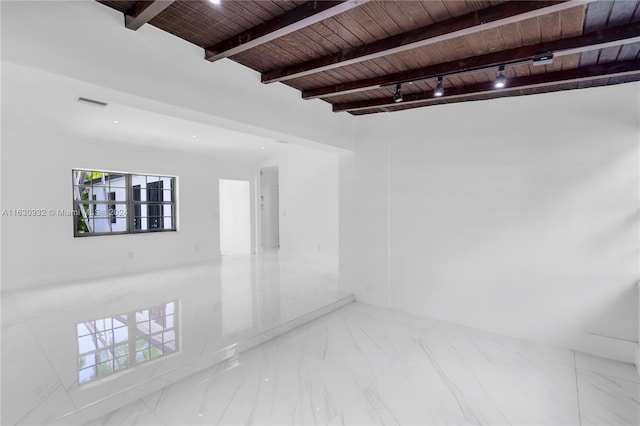 unfurnished room with tile patterned flooring, beamed ceiling, wood ceiling, and plenty of natural light