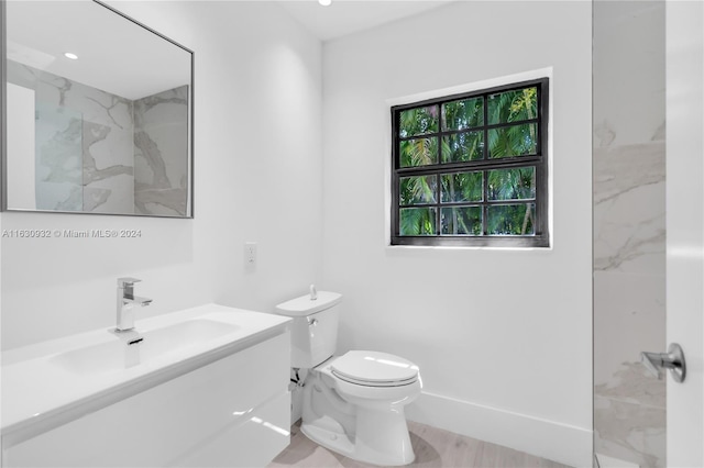 bathroom featuring vanity, tiled shower, toilet, and wood-type flooring