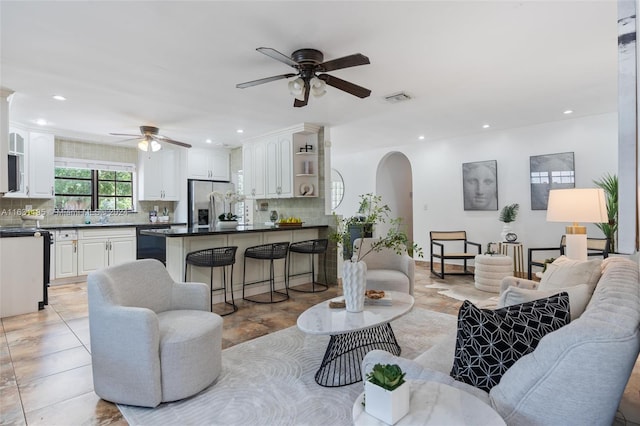 living room featuring ceiling fan and sink