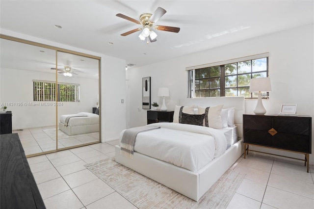 bedroom featuring light tile patterned floors, ceiling fan, and a closet