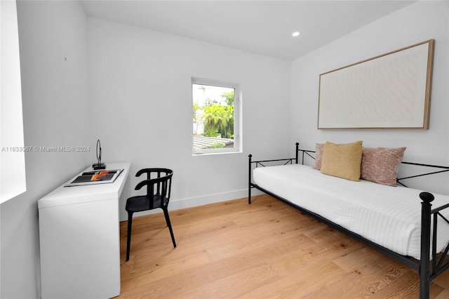 bedroom with washer / dryer and light hardwood / wood-style flooring