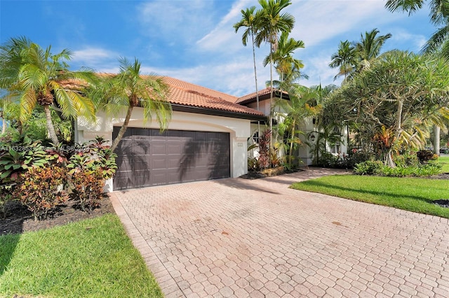 mediterranean / spanish house featuring a garage and a front lawn