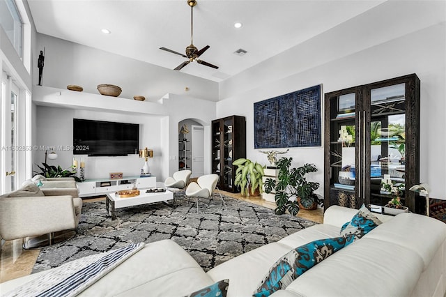 living room with ceiling fan and a high ceiling