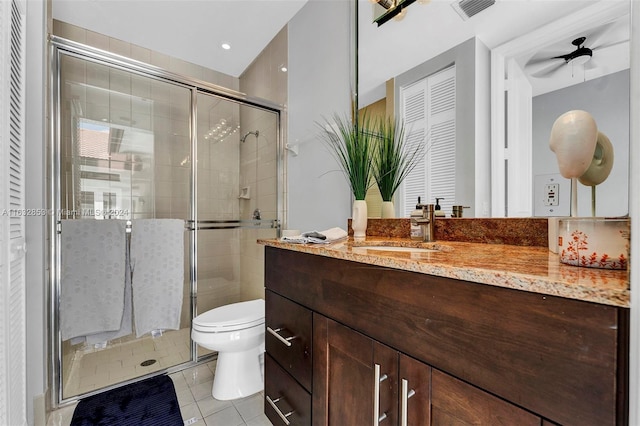 bathroom featuring tile patterned floors, toilet, a shower with door, and vanity