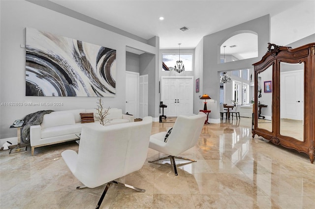 living room featuring a towering ceiling and a notable chandelier