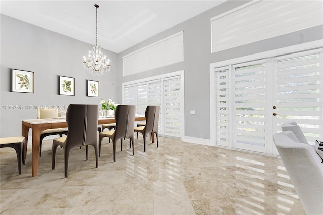 dining room with french doors, a chandelier, and a high ceiling