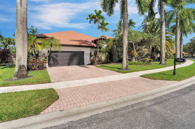 mediterranean / spanish home with a garage and a front yard