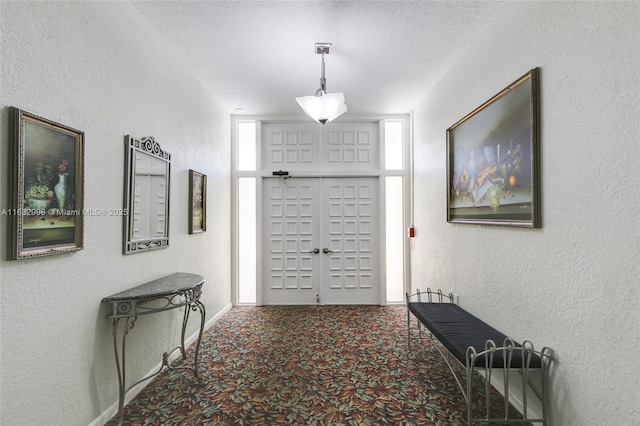 carpeted entryway featuring a textured ceiling