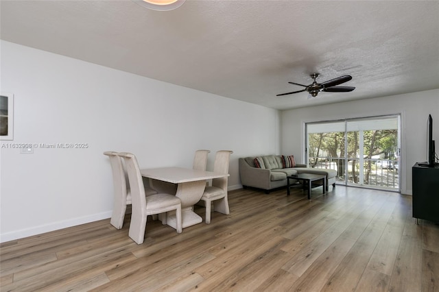 dining space featuring a textured ceiling, light wood-type flooring, and ceiling fan