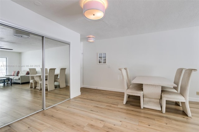 dining area with ceiling fan, a textured ceiling, and light hardwood / wood-style flooring