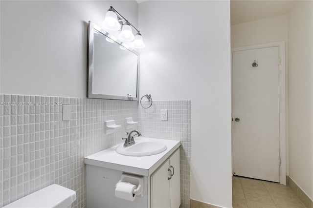 bathroom with tile patterned flooring, vanity, tile walls, and toilet