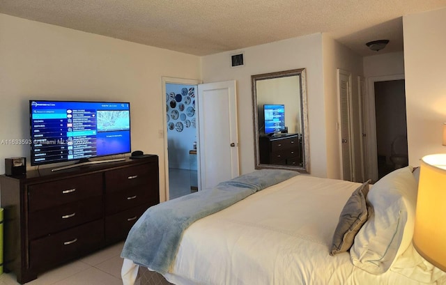 bedroom featuring a textured ceiling and light tile patterned floors