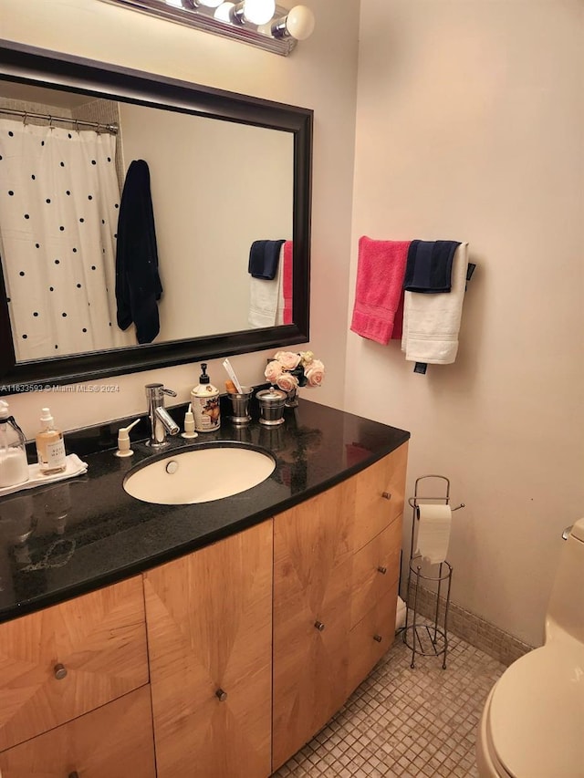 bathroom featuring vanity, toilet, and tile patterned flooring