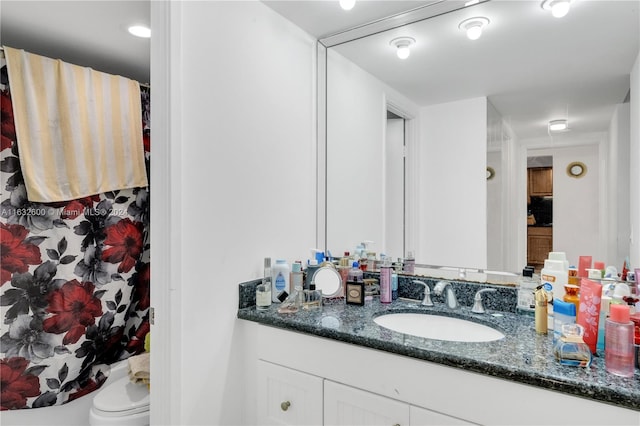 bathroom featuring vanity, toilet, and a shower with shower curtain