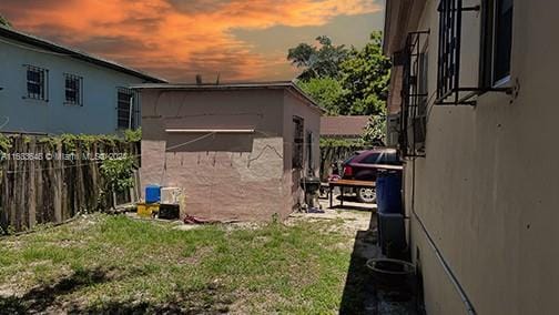 property exterior at dusk with a lawn