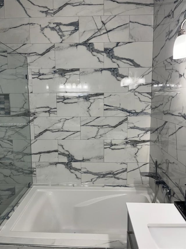 bathroom with vanity and a washtub