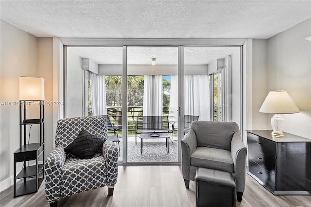 living room with a textured ceiling and light wood-type flooring