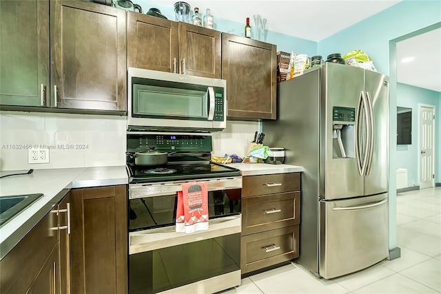 kitchen featuring dark brown cabinetry, appliances with stainless steel finishes, electric panel, and light tile patterned floors