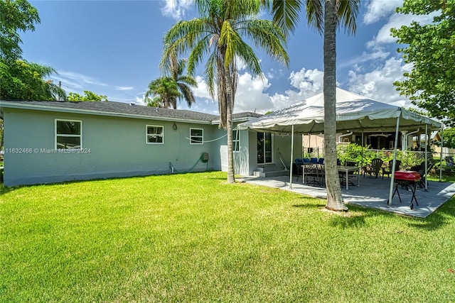 rear view of house with a yard and a patio area