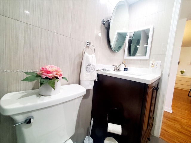 bathroom featuring wood-type flooring, toilet, and vanity