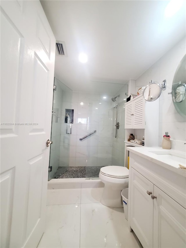 bathroom with vanity, a shower with shower door, toilet, and tile patterned floors