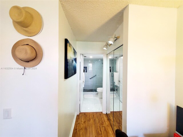 hallway featuring tile patterned flooring and a textured ceiling