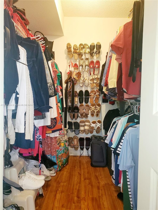 walk in closet with hardwood / wood-style floors