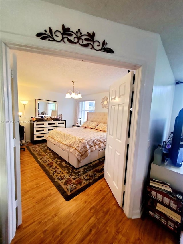 bedroom featuring wood-type flooring and a chandelier