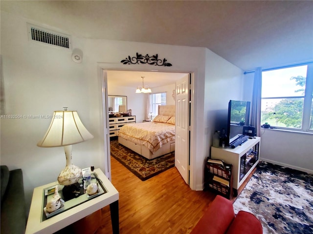 bedroom featuring hardwood / wood-style flooring and a notable chandelier