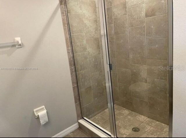 bathroom with a shower with door and toilet