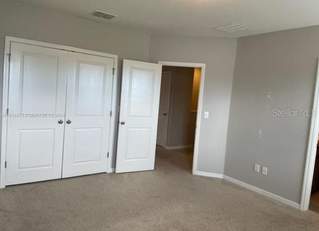 unfurnished bedroom with carpet flooring and a closet