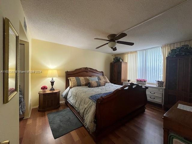 bedroom with a textured ceiling, ceiling fan, and hardwood / wood-style floors