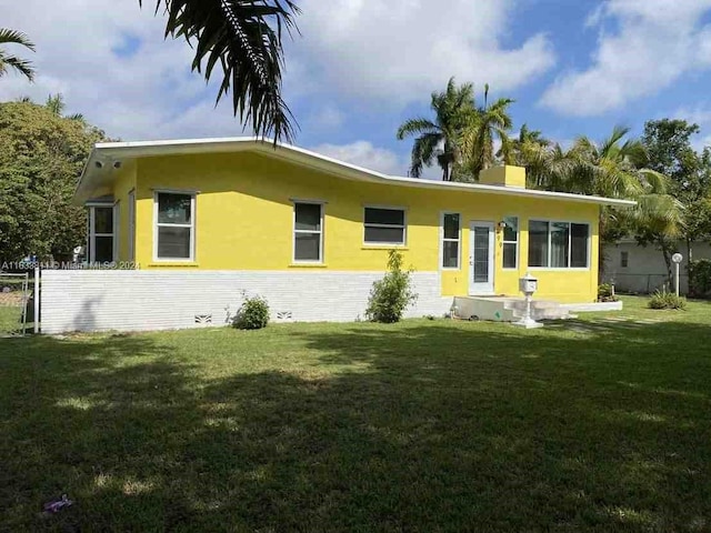 rear view of property with a lawn