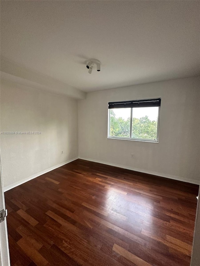 unfurnished room with dark hardwood / wood-style floors