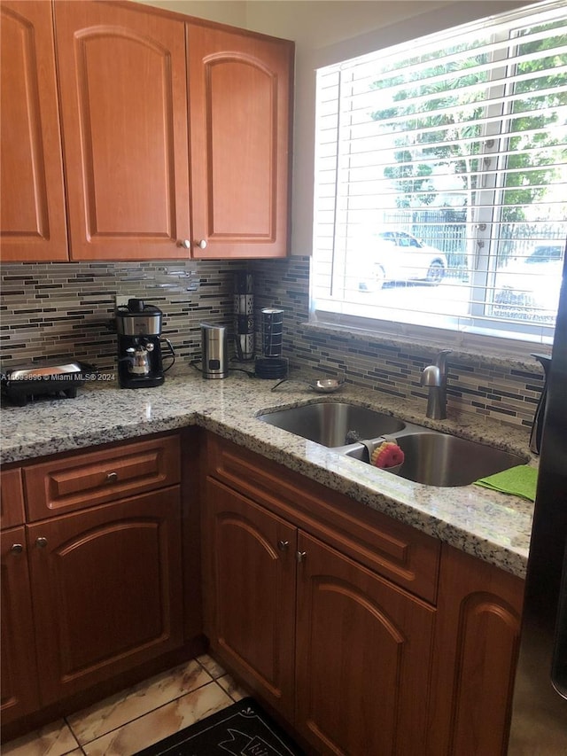 16700 NW 55th Ave Unit 12, Miami Gardens, FL 33055 - kitchen with backsplash, light tile patterned flooring, a sink, and light stone countertops