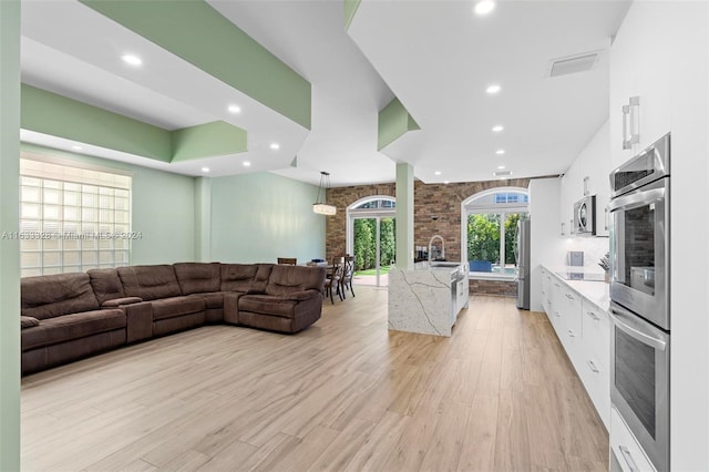 living room with sink and light wood-type flooring