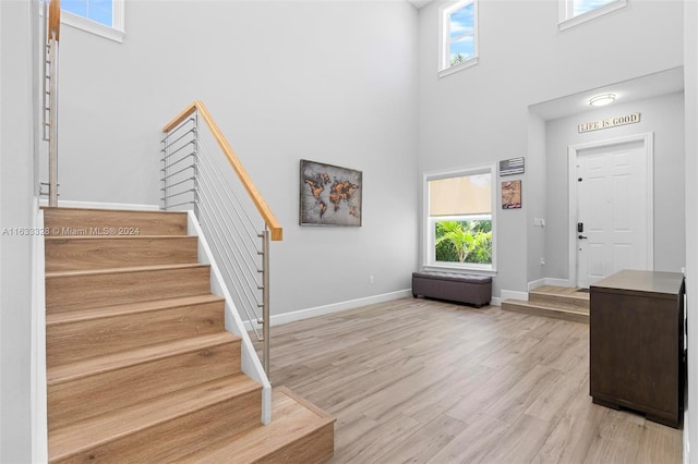 entryway with light hardwood / wood-style flooring and a high ceiling