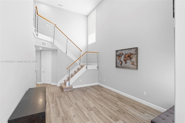 interior space with a towering ceiling and light wood-type flooring