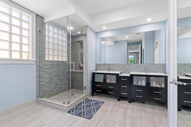 bathroom featuring walk in shower, vanity, and backsplash