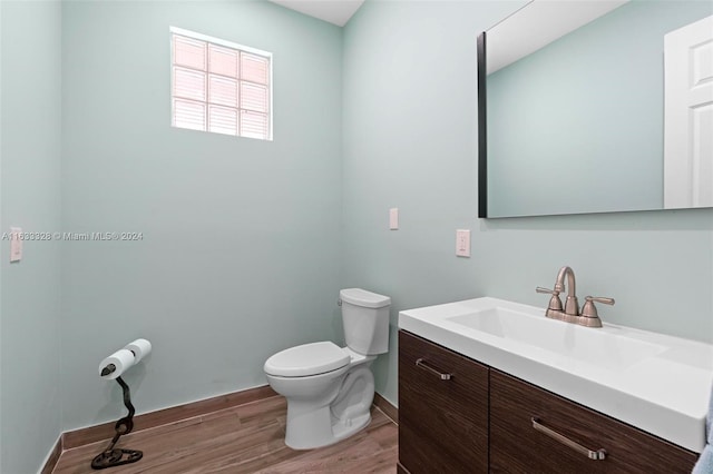 bathroom featuring vanity, hardwood / wood-style floors, and toilet