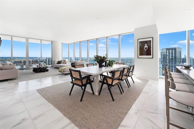 tiled dining room featuring a water view and floor to ceiling windows