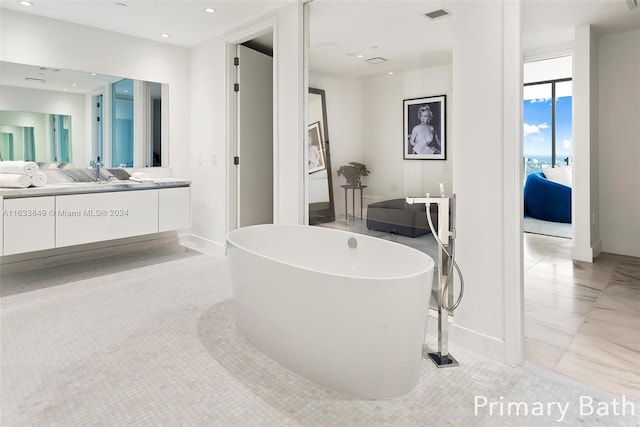 bathroom featuring vanity, tile patterned flooring, and a washtub