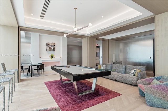 game room featuring light parquet floors, pool table, and a tray ceiling