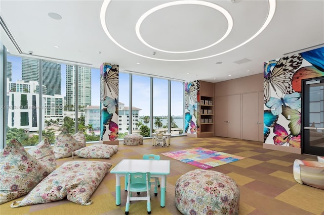 interior space with floor to ceiling windows, a tray ceiling, and recessed lighting