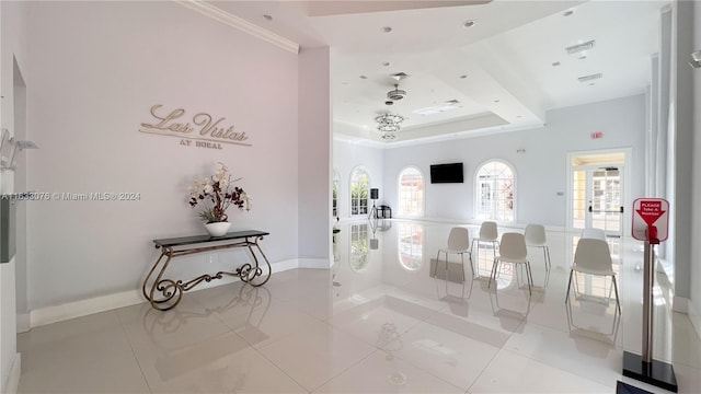 tiled living room featuring a tray ceiling and ornamental molding