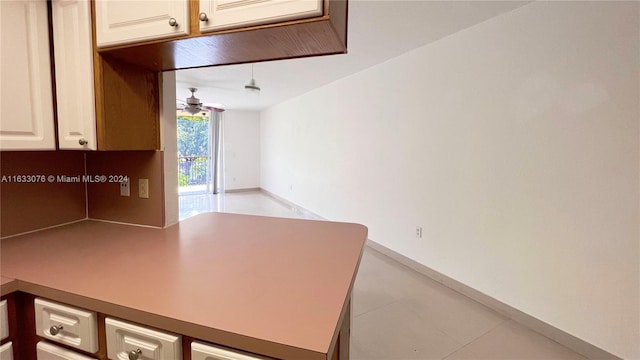 interior space with ceiling fan and light tile patterned floors