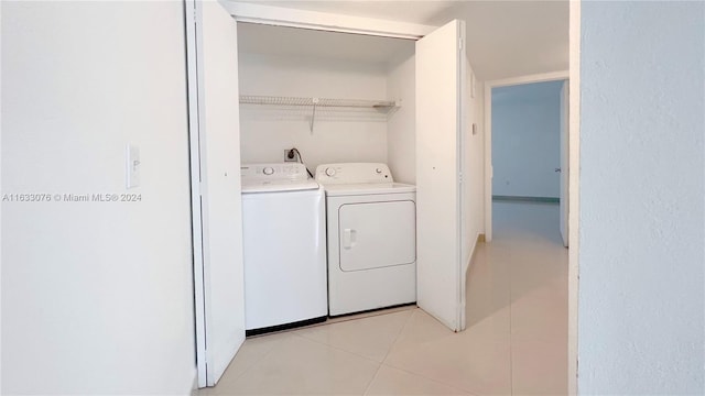 clothes washing area featuring light tile patterned flooring and independent washer and dryer